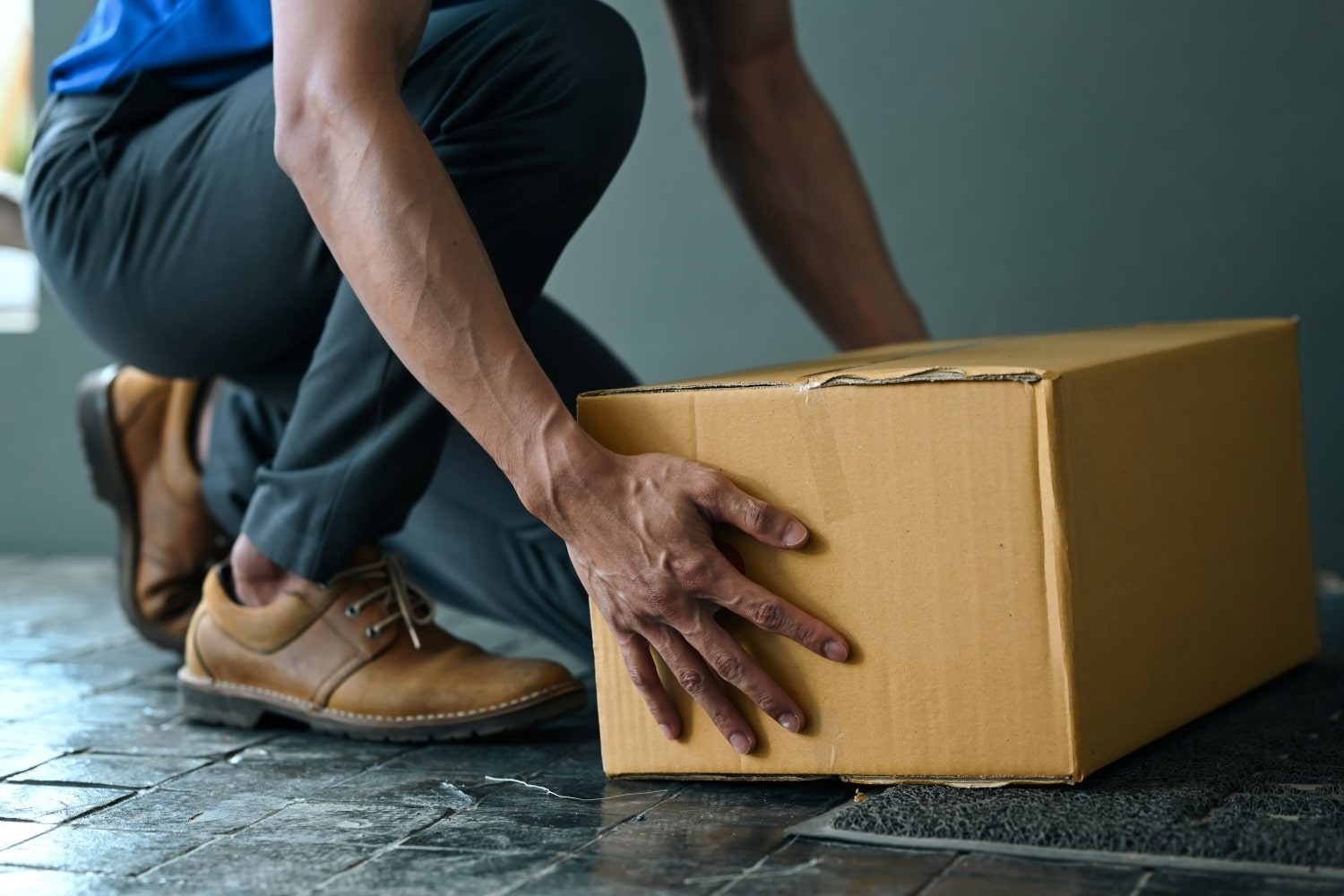 cropped-image-of-male-courier-putting-parcel-cardb-2023-01-25-11-25-03-utc-min.jpg