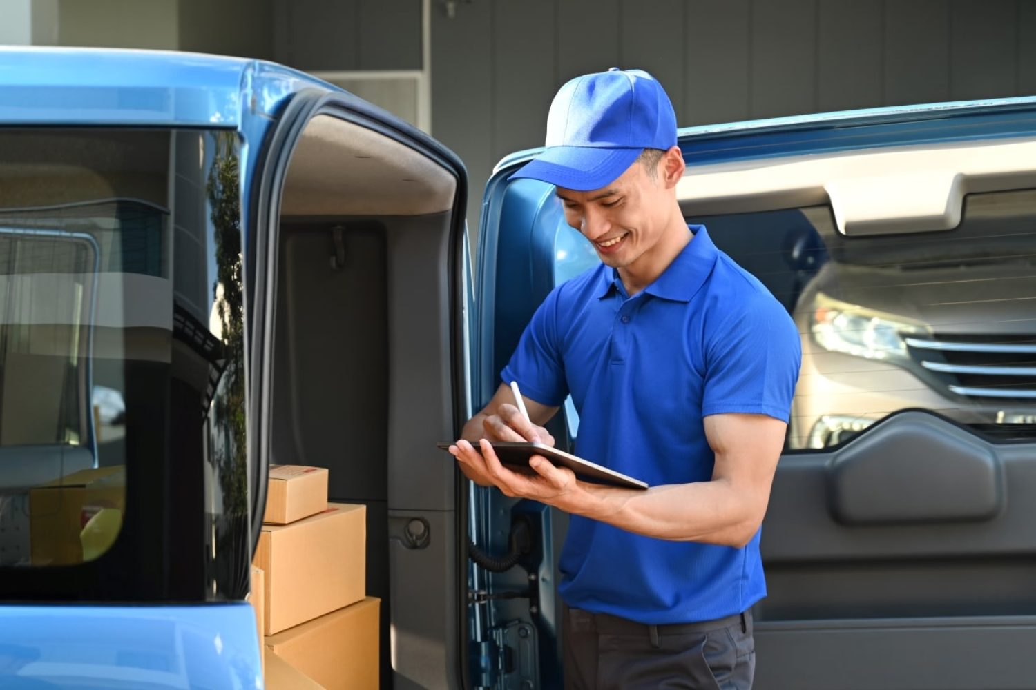 delivery-man-in-blue-uniform-using-digital-tablet-2023-01-25-11-25-00-utc-min.jpg